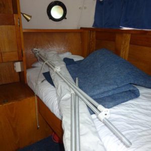 Jachtreparatie vooraanzicht slaapkamer bed met witte lakens en dekbed