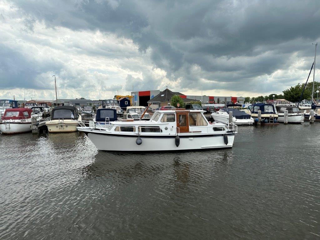 Zij aanzicht van varende witte Boot huren Sneekweek