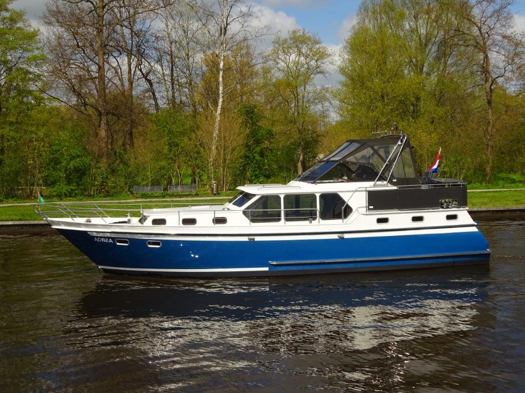 Boten te koop In Sneek zijaanzicht witte boot met blauwe accenten